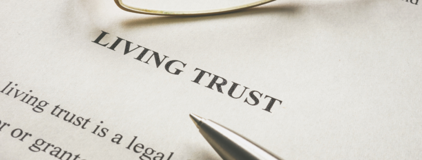 Close-up of a legal document labeled 'Living Trust' with a pen and glasses resting on the page, symbolizing estate planning and financial preparation.