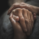 Close-up of an elderly hand held gently by another, symbolizing care, trust, and the importance of incapacity planning.