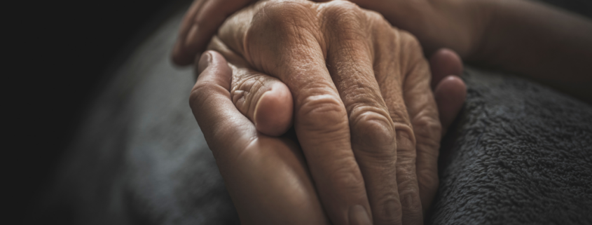 Close-up of an elderly hand held gently by another, symbolizing care, trust, and the importance of incapacity planning.